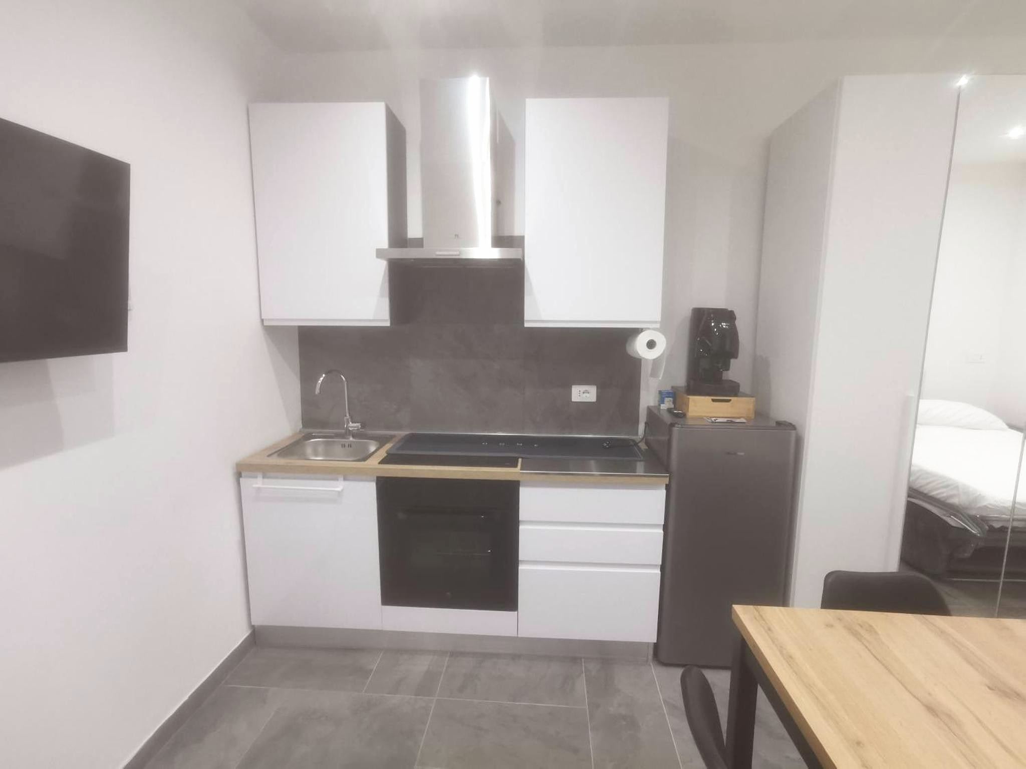 Cucina del monolocale con piano cottura e frigorifero